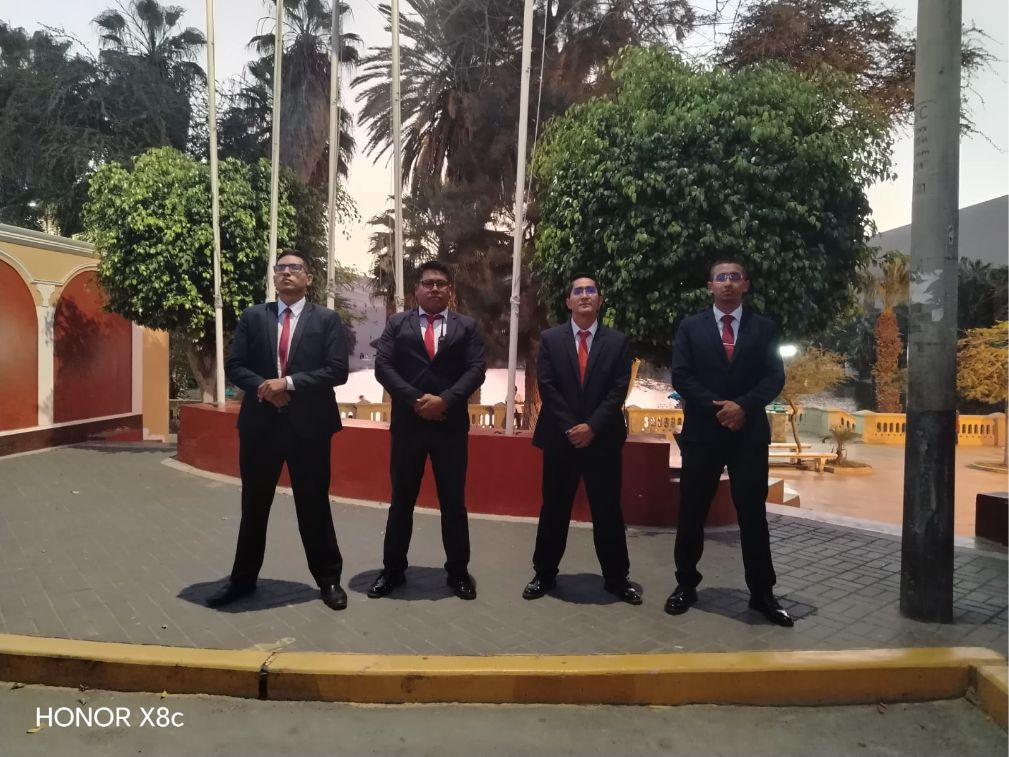 Cuatro integrantes del equipo de José Ostolaza con traje formal en un entorno hotelero